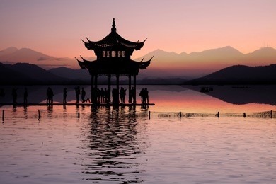 ancient pavilion on the west lake with sunset in hangzhou,china.
