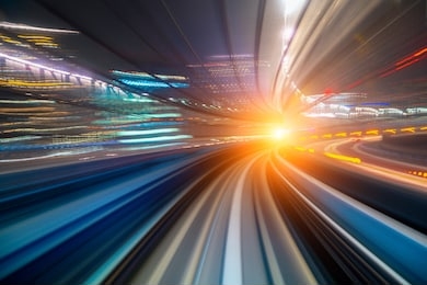 motion blur of a city and tunnel from inside a moving monorail in tokyo. abstract motion speed railway tunnel with city background