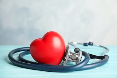 stethoscope and red heart on wooden table. cardiology concept