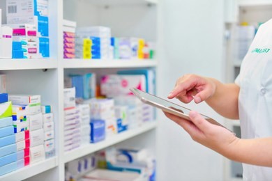 pharmacist holding computer tablet using for filling prescription in pharmacy drugstore. 