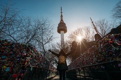 young woman traveler traveling into the love key ceremony wall with happiness on n seoul tower at namsan mountain in seoul city, south korea.