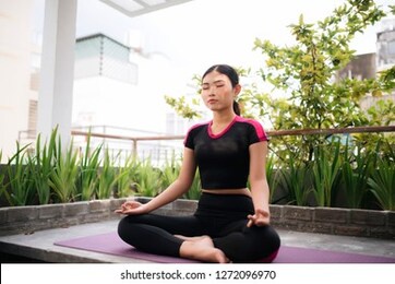 beautiful woman doing yoga outdoors on a rooftop terrace