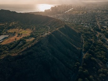 aerial drone shot of diamond head crater with the skyline of honolulu in the background