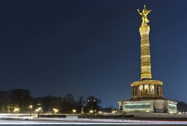 the victory column is a famous sight in berlin. impressive siegessaule monument with its golden angel overlooking the huge tiergarten park in berlin at night.