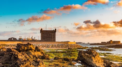 beautiful sunset sky with the ruins of old fortress in essaouira, morocco 