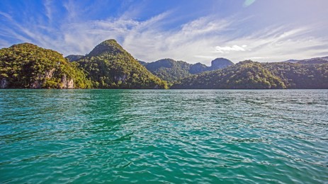 simple nature theme image showing green ocean, interesting mountain ranges and blue sky shot at dayang bunting island in langkawi, kedah, malaysia.