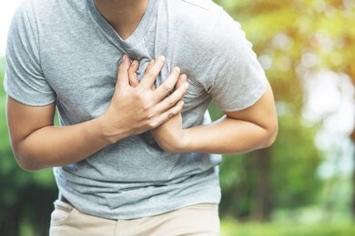 man having chest pain - heart attack outdoors. or heavy exercise causes the body to shocks heart disease	