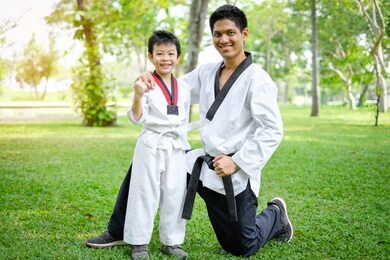 father is teacher teaching taekwondo kids, children boy are learning taekwondo in the nature park
