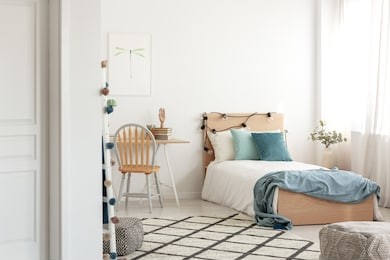 white and wood scandinavian kid's room with comfortable single bed and workspace with desk and chair