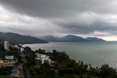 view of a tropical storm approaching batu ferringhi beach and penang national park located in the malacca strait on penang island, malaysia. batu ferringhi is a popular travel destination for tourism.
