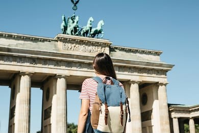 a tourist or a student with a backpack near the brandenburg gate in berlin in germany, looks at the sights.