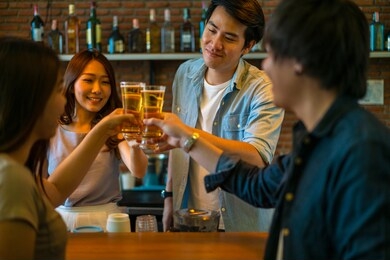 group of asian friend clinking a glass of beer and enjoy drinking beer at bar, alcohol, beer drinking, friend party, group of friend, casual meeting, bar and restaurant or friend and beer concept 