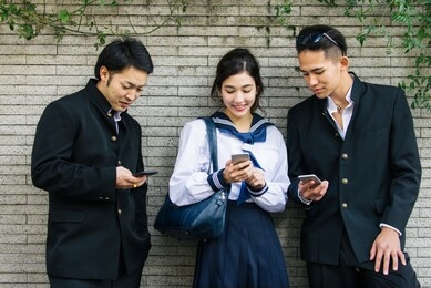 yung japanese students with school uniform bonding outdoors - group of asian teenagers having fun