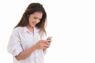 beautiful asian woman smiling and using smartphone isolated on white background. thai female happy holding phone in hand free from copy space.
