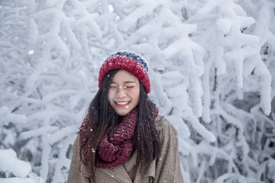 portrait of woman with red wool hat feeling very happy and cold under snowy weather at shin-hotaka, japan alps.