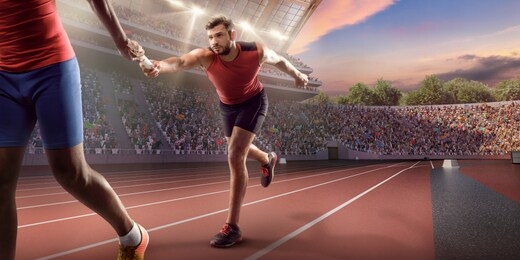 male athletes sprinting. runner passes the baton at the running track in professional stadium