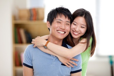 happy young asian couple isolated in home background.