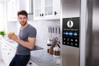 man standing near oven with voice recognition function in kitchen