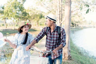 happy couple with bicycle against the autumn background park. filtered image.