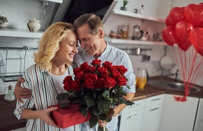 love has no age! romantic senior couple celebrating saint valentine's day at home. beautiful woman and handsome man enjoying spending time together. happy saint valentine's day!