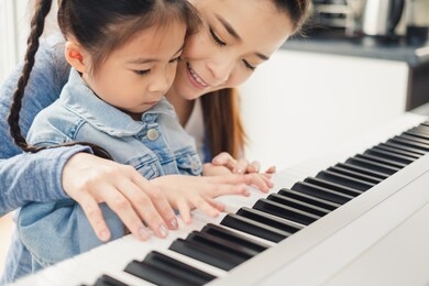 asian young pianist teacher teaching girl kid student to play piano, music education concept