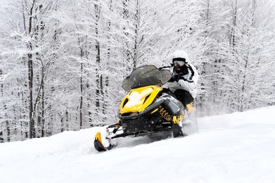 man on snowmobile in winter mountain