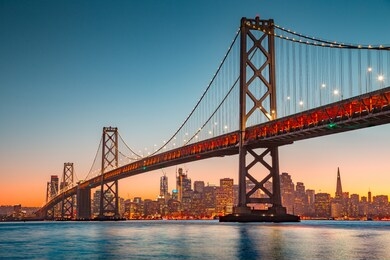 classic panoramic view of san francisco skyline with famous oakland bay bridge illuminated in beautiful golden evening light at sunset in summer, san francisco bay area, california, usa