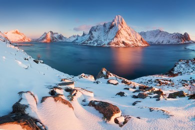 panoramic landscape, winter mountains and fjord reflection in water. norway, the lofoten islands. colorful winter sunset or sunrise above the arctic circle.