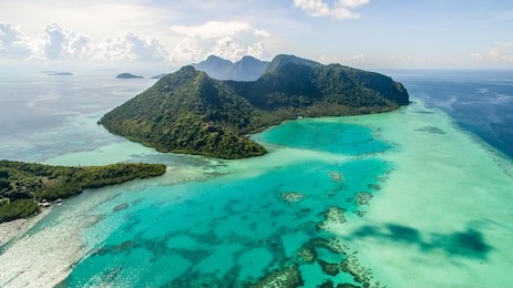 aerial view of bohey dulang island panorama, beautiful blue lagoon and coral reef.