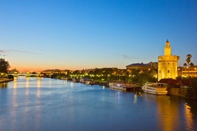 cityscape with river of sevilla at night, spain