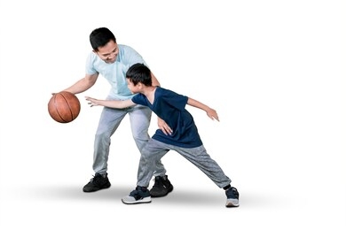 picture of a young man and his son playing basketball while exercising in the studio, isolated on white background