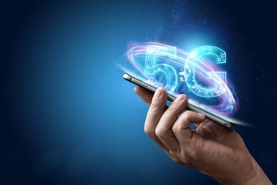 creative background, male hand holding a phone with a 5g hologram on the background of the city. the concept of 5g network, high-speed mobile internet, new generation networks. mixed media.