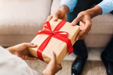 father hands giving birthday gift to daughter, closeup