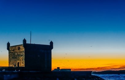 sunset in essaouira, morocco. fort in the fishing port.