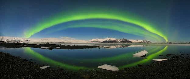 this beautiful northern lights or aurora borealis in iceland dancing over the above jokulsarlon glacier lagoon and black beach with icebergs.
beautiful iceland in winter.green aurora kp 4 polar lights