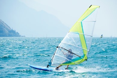 windsurfing on lake garda. unidentifiable windsurfer surfing the wind on waves, recreational water sports, selective focus