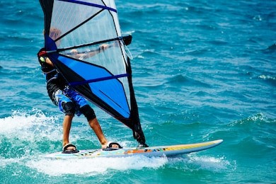 windsurfing on lake garda. unidentifiable windsurfer surfing the wind on waves, recreational water sports, selective focus