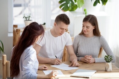 happy family couple sign contract sale purchase agreement meeting realtor insurer broker advisor closing real estate or financial deal buying house insurance, taking bank loan, mortgage investment