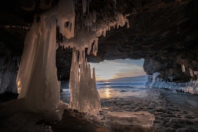 ice  cave   with  icicle  and  sunset background    at   lake  baikal    northern  siberia  russia.