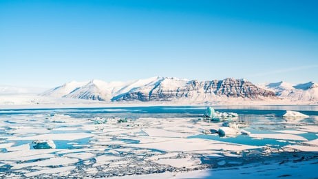 jokulsarlon, the glacier lagoon in iceland near by reykjavik, there are many glaciers  floating in the lagoon and the snow mountain in background. it is blue tone icelandic background.
