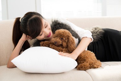 portrait of a girl lying on a cushion with a puppy