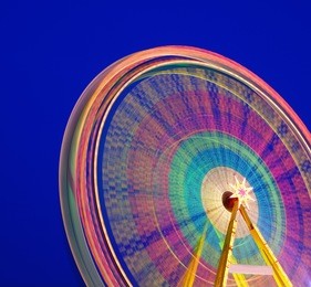 carousel. ferris wheel on a blue background. long time exposure.