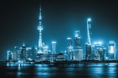 the skyscrapers of shanghai lit up at night along the bund.