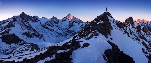 view of snow covered landscape with  dent blanche and weisshorn mountain in the swiss alps, zermatt. panorama of the weisshorn and surrounding mountains in switzerland. climber stand top of mountain