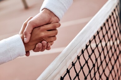 two tennis players are shaking hands