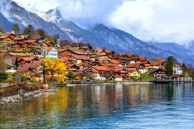old town of oberried, brienz, interlaken and misty alps mountains reflecting in lake, switzerland