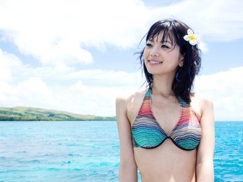 a young beautiful asian woman in the blue ocean