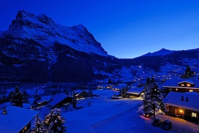 grindelwald village at dusk with mt. eiger peak in the background, snow covered landscape in winter, grindelwald, bern, switzerland, europe