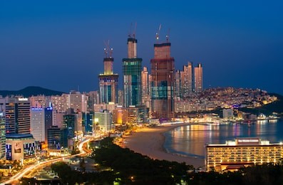 busan beach view from roof top busan city in night time with blue sky and full moon, south korea, this picture can use for tavel, busa, south korea and  city concept