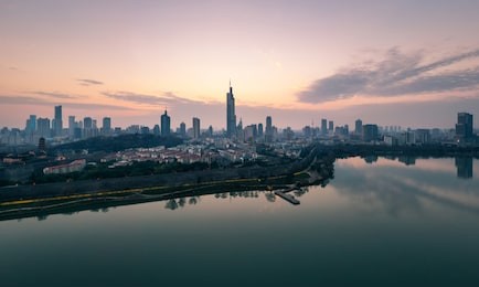 skyline of nanjing city at sunset. image taken with a drone flying over xuanwu lake.